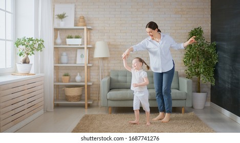 Happy mother's day! Mom and her daughter child girl are playing, smiling and dancing. Family holiday and togetherness.                               
