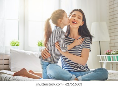 Happy Mother's Day! Mom And Her Daughter Child Girl Are Playing, Smiling And Hugging. Family Holiday And Togetherness.