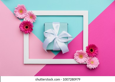 Happy Mother's Day, Women's Day, Valentine's Day or Birthday Pastel Candy Colours Background. Floral flat lay minimalism geometric patterns greeting card with a gift box.