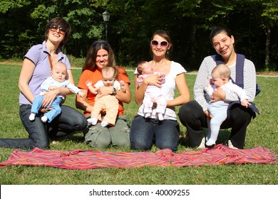 Happy Mothers With Their Newborn Babies In Park