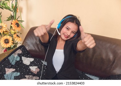 A Happy And Motuvated Call Center Agent Working Remotely At Home Giving A Double Thumbs Up. Satisfied About Her Job Performance And Company Perks.