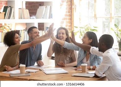 Happy multi ethnic creative business startup team associates group join hands giving high five together celebrate success teamwork, corporate vision teambuilding, connection participation concept