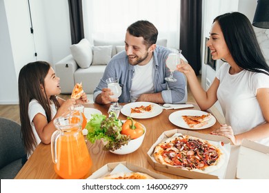 Happy Multi Ethnic Family, Mother, Father And Daughter During Dinner.Eating Delicious Pizza With Family