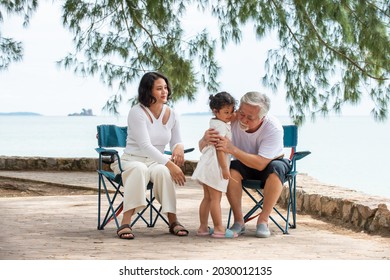 Happy Multi Generation Asian Family Enjoy Picnic Travel Together On The Beach In Summer. Parents With Retired Senior Grandparent And Cute Child Girl Relax And Having Fun On Summer Holiday Vacation