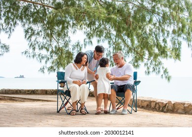 Happy Multi Generation Asian Family Enjoy Picnic Travel Together On The Beach In Summer. Parents With Retired Senior Grandparent And Cute Child Girl Relax And Having Fun On Summer Holiday Vacation