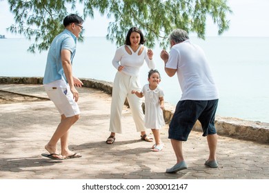 Happy Multi Generation Asian Family Enjoy Picnic Travel Together On The Beach In Summer. Parents With Retired Senior Grandparent And Cute Child Girl Relax And Having Fun On Summer Holiday Vacation