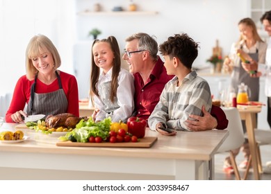 Happy Multi Generation Family With Grandparents And Grandkids Cooking Festive Thanksgiving Or Christmas Meal, Preparing Yummy Turkey For Holiday Celebration, Making Dinner Together At Kitchen