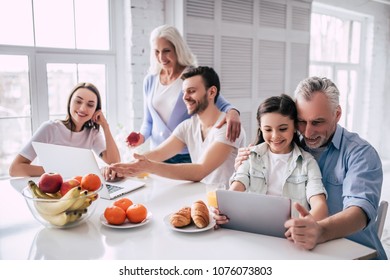 The Happy Multi Generation Family Sitting With A Laptop And The Tablet