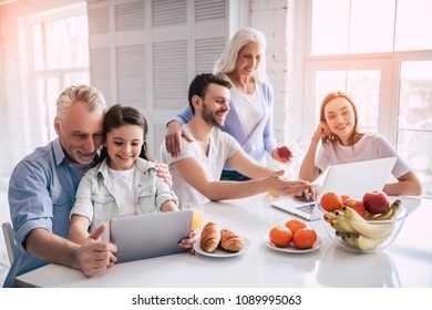 The Happy Multi Generation Family Sitting With A Laptop And The Tablet