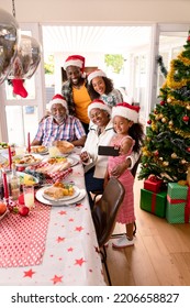 Happy Multi Generation Family Wearing Santa Hats, Taking Selfie. Family Christmas Time And Festivity Together At Home.