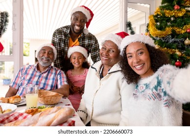 Happy Multi Generation Family Wearing Santa Hats, Taking Selfie. Family Christmas Time And Festivity Together At Home.