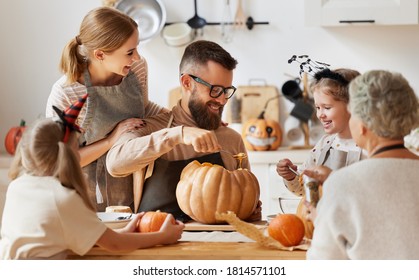 Happy Multi Generational Family Smiling And Carving Jack O Lantern From Pumpkin While Gathering Around Table During Halloween Celebration
