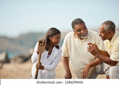 Happy Multi Generational Family Talking On A Beach.