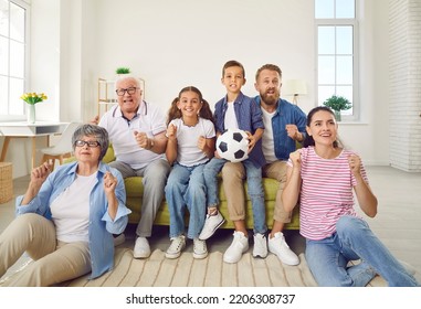 Happy Multi Generational Family Watching Football On TV. Parents, Kids And Grandparents Watching Soccer At Home. Excited Mom, Dad, Grandpa, Grandma And Kids Sitting On Sofa In Cozy House Or Apartment