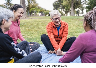 Happy Multi Generational Women Having Fun Together Sitting Outdoors At City Park - Main Focus On Center Senior Female Arms