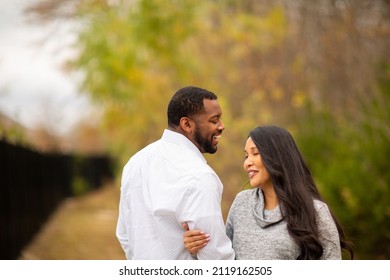 Happy Multicultural Couple Smiling And Laughing Outside.