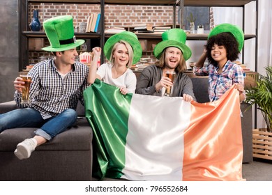 Happy Multicultural Friends Watching Tv On Saint Patrick Day With Irish Flag