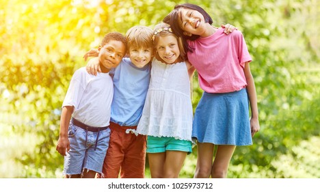 Happy Multicultural Group Of Kids Hugs Each Other In Summer