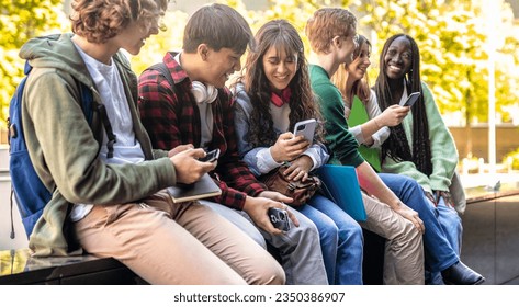 Happy multicultural group of people using smartphone outdoors - Young people having fun together while watching social media
