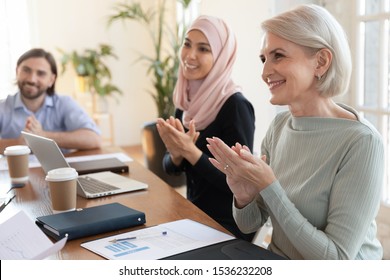 Happy multicultural old and young business audience people group applauding sitting at table clapping hands at corporate training seminar negotiation team meeting, conference applause ovation concept - Powered by Shutterstock