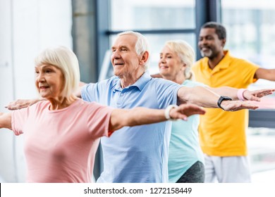 Happy Multicultural Senior Athletes Synchronous Doing Exercise At Gym