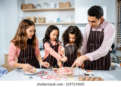 Happy Multiethnic Family Cooking Creams Cake Together In The Kitchen At Home. A Parent Teaches Daughters To Make Homemade Desserts, Enjoy Leisure Activities Time, Family 