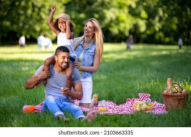 Happy multiethnic family enjoying picnic in nature