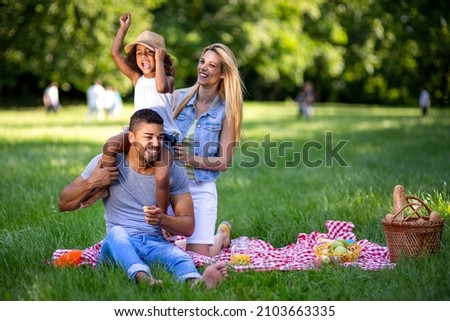 Happy multiethnic family enjoying picnic in nature