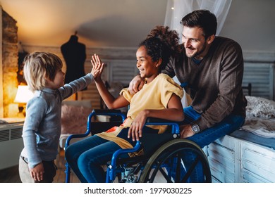 Happy multiethnic family. Smiling little girl with disability in wheelchair at home