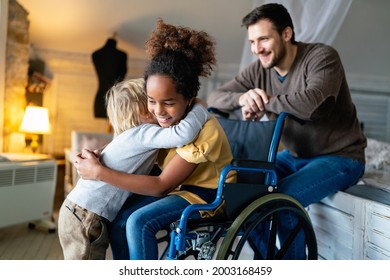 Happy multiethnic family. Smiling little girl with disability in wheelchair - Powered by Shutterstock