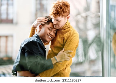 Happy multiethnic gay couple embracing at home - Powered by Shutterstock