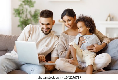 Happy multiethnic parents and amazed mixed race boy watching video on laptop while resting on couch at home together
 - Powered by Shutterstock