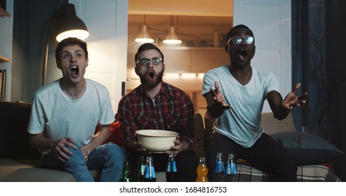 Happy Multiethnic Young Men Watch Sports Game, Cheer Together At Home With Snacks Using Big Projector Screen Slow Motion