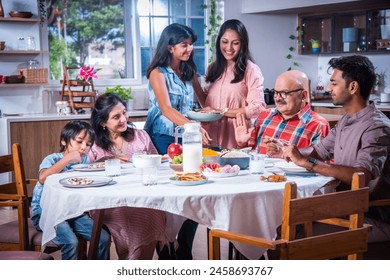 Happy multi-generation asian Indian family enjoying lunch together at home. - Powered by Shutterstock