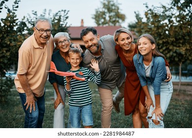 Happy multigeneration family in the backyard looking at camera. - Powered by Shutterstock