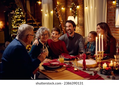 Happy multigeneration family communicating while gathering for dinner at Christmas.  - Powered by Shutterstock