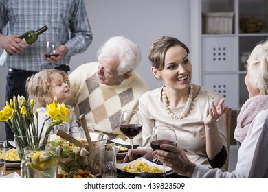 Happy Multi-generation Family Discussing And Eating Dinner At The Table