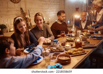 Happy Multi-generation Family Eating Traditional Jewish Food While Celebrating Hanukkah At Dining Table.