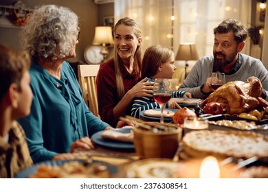 Happy multigeneration family enjoying in conversation during Thanksgiving meal at dining table. - Powered by Shutterstock