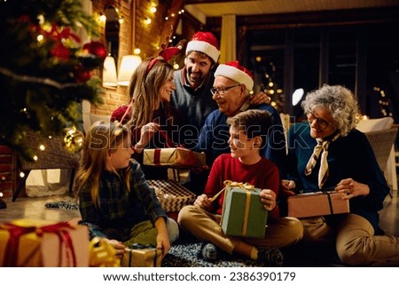 Happy multigeneration family enjoying in opening gifts on Christmas eve at home.