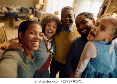 Happy multigeneration family having fun on Thanksgiving while taking selfie and looking at camera.  - Powered by Shutterstock