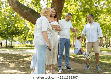 Happy multi-generation family having fun, playing with child in park - Powered by Shutterstock