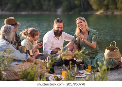 Happy Multigeneration Family On Summer Holiday Trip, Barbecue By Lake.