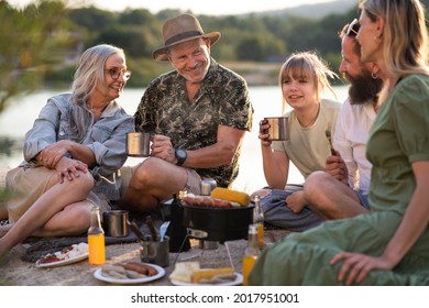 Happy Multigeneration Family On Summer Holiday Trip, Barbecue By Lake.