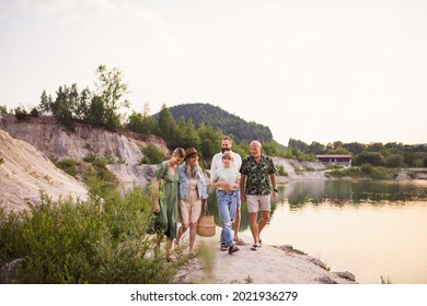 Happy Multigeneration Family On Summer Holiday, Walking By Lake.