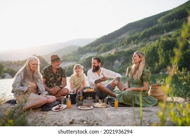 Happy multigeneration family on summer holiday trip, barbecue by lake. - Powered by Shutterstock