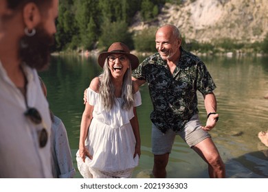 Happy Multigeneration Family On Summer Holiday, Having Fun By Lake.