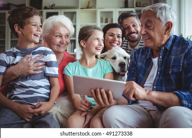 Happy multi-generation family using digital tablet in living room at home - Powered by Shutterstock