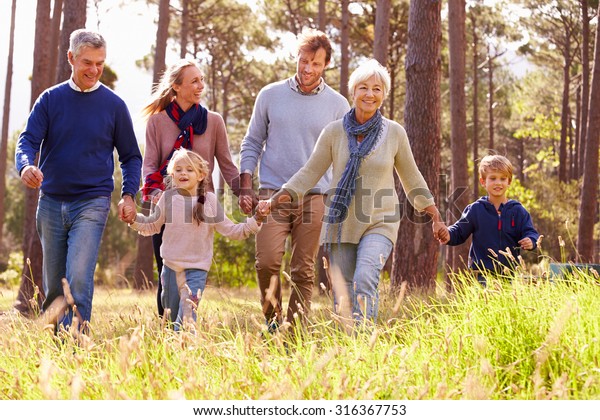 Happy\
multi-generation family walking in the\
countryside