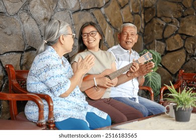 Happy multigenerational family group sitting on sofa while spending time together with music at home - Powered by Shutterstock